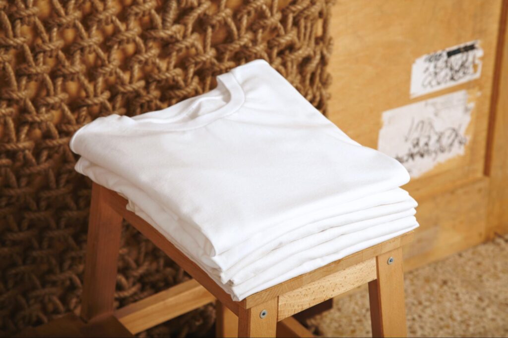 A stack of freshly cleaned white shirts, folded and ready to wear