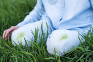 Close-up of grass stain on the knee of blue jeans