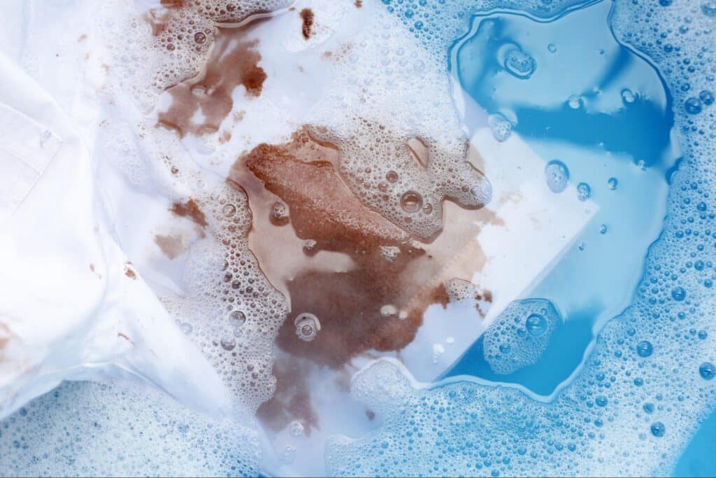 Soaking a white shirt’s underarm area in a basin of vinegar water