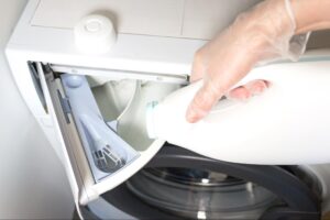 bottle of white vinegar and laundry basket of clothes