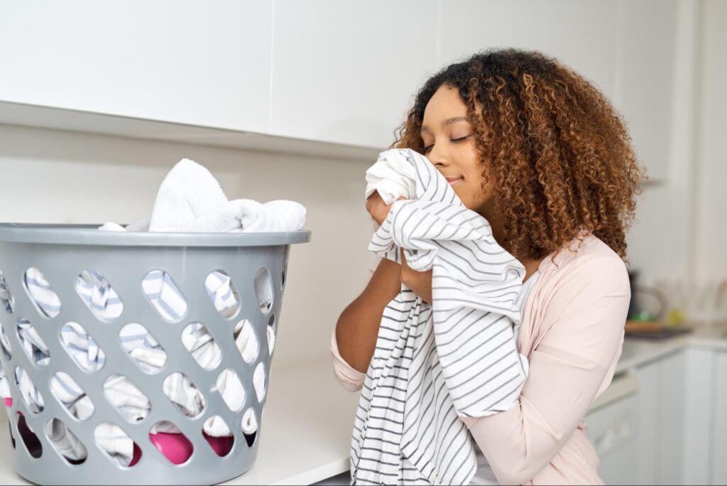 woman smelling freshly washed laundry with a smile