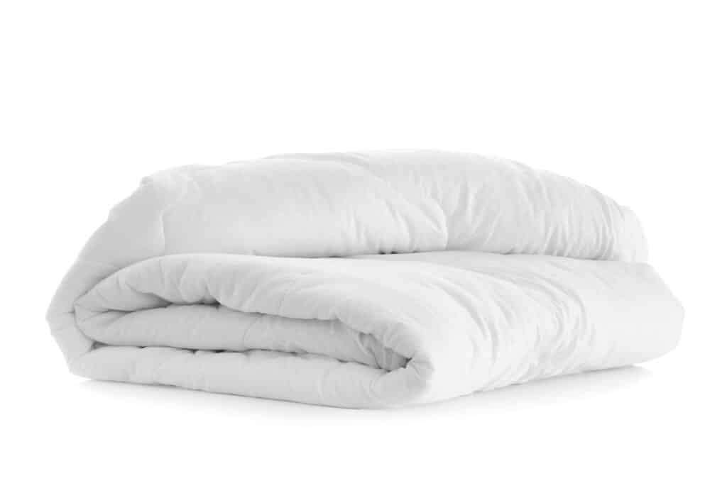 Folded comforter on white background