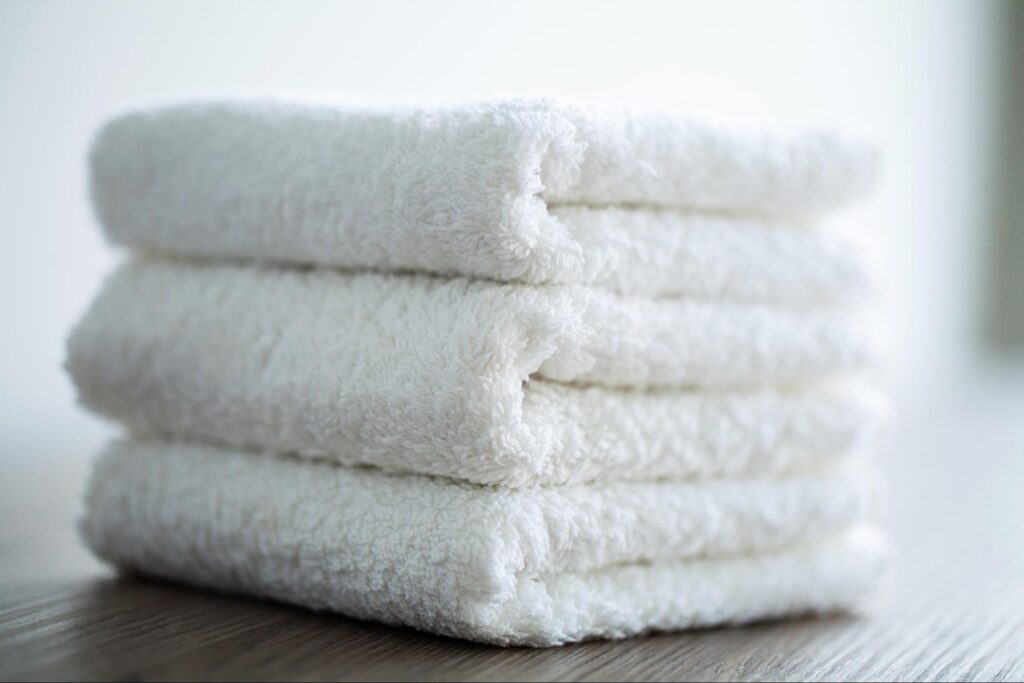 A stack of fluffy, freshly folded towels from the dryer