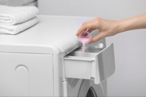 Pouring liquid fabric softener into a washing machine dispenser