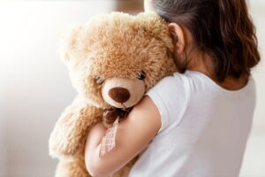 Child hugging a clean stuffed teddy bear