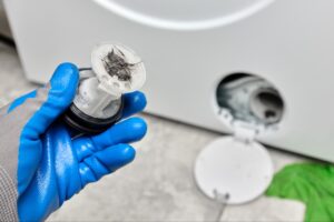 Open washing machine filter compartment at the bottom of a front-load washer