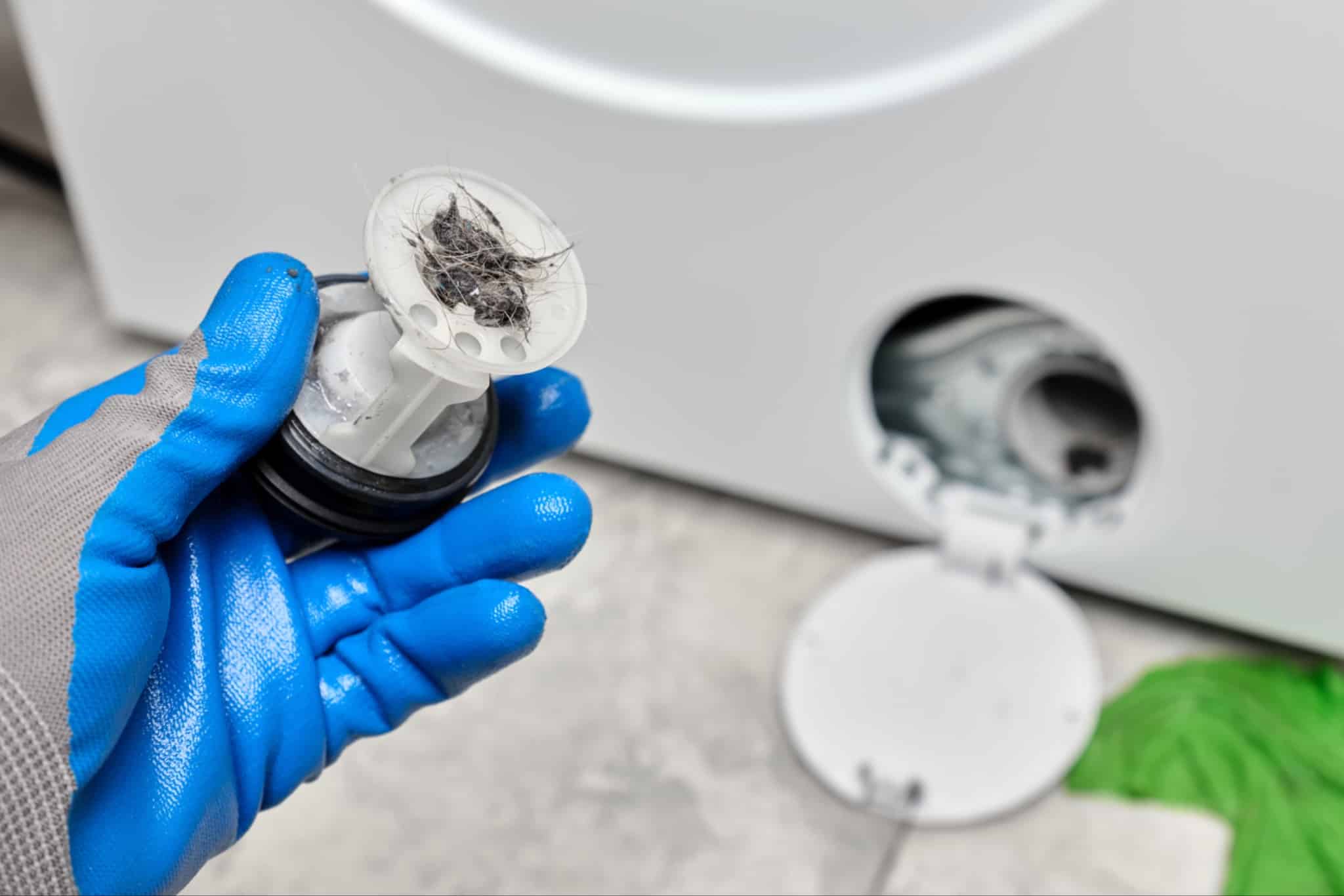 Open washing machine filter compartment at the bottom of a front-load washer