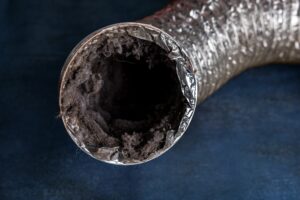 Close-up of a lint-clogged dryer vent tube filled with fuzz and debris