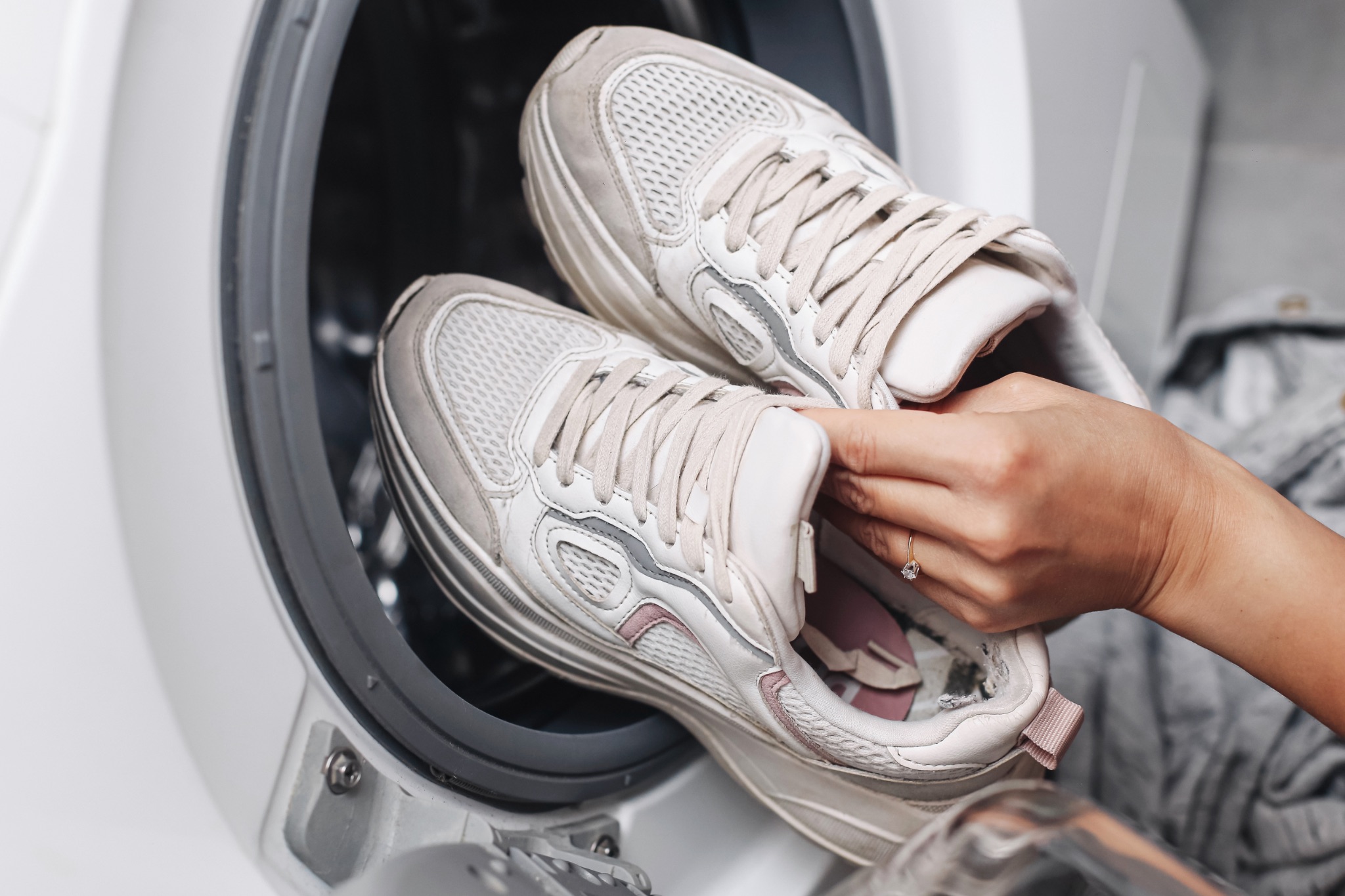 sneakers-being-loaded-into-washer.