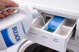 Bleach being poured into a washing machine bleach dispenser