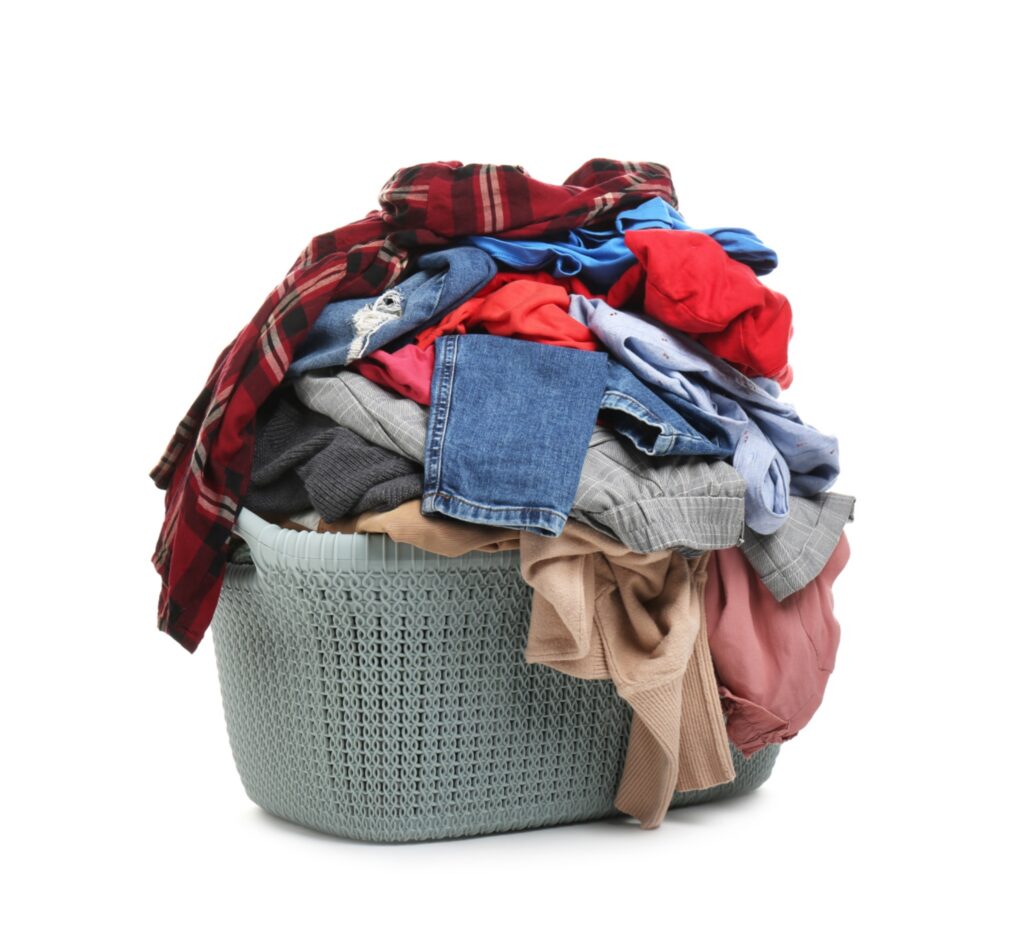 Overflowing laundry basket filled with mixed clothes