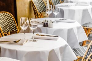 Restaurant tables with white tablecloths and folded napkins