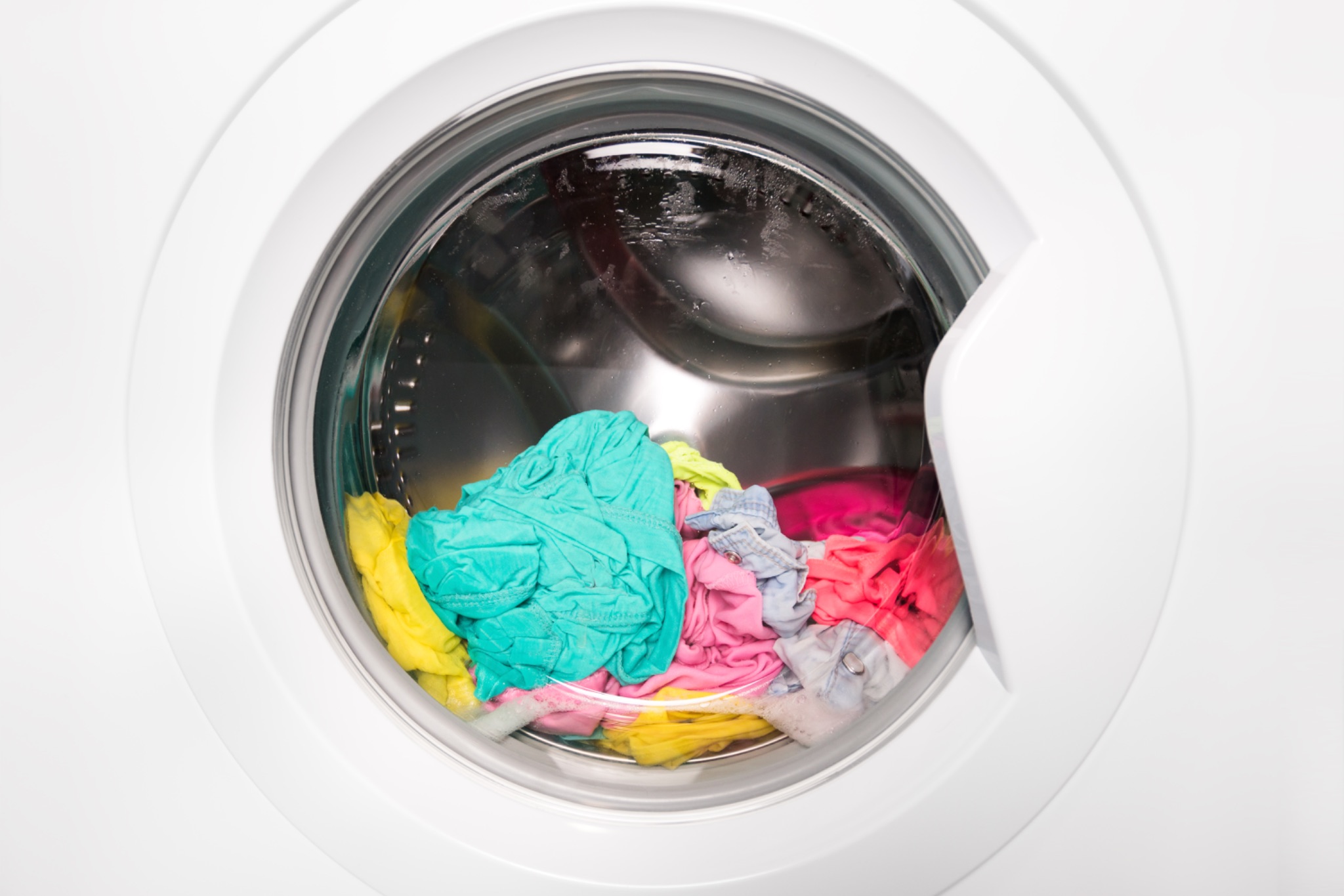 Wet laundry sitting inside a front load washing machine