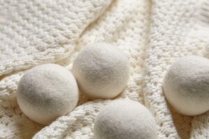 Wool dryer balls resting on a knitted blanket