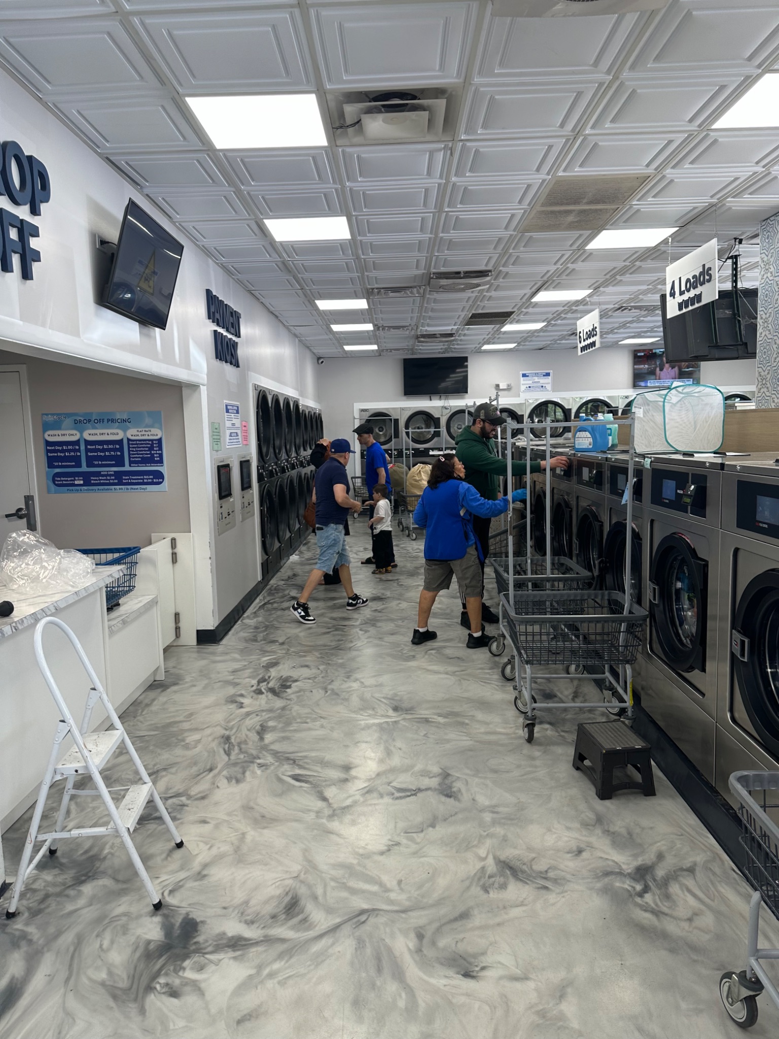 People using washing machines in laundromat