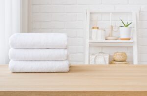 Stacked White Towels On Wooden Table