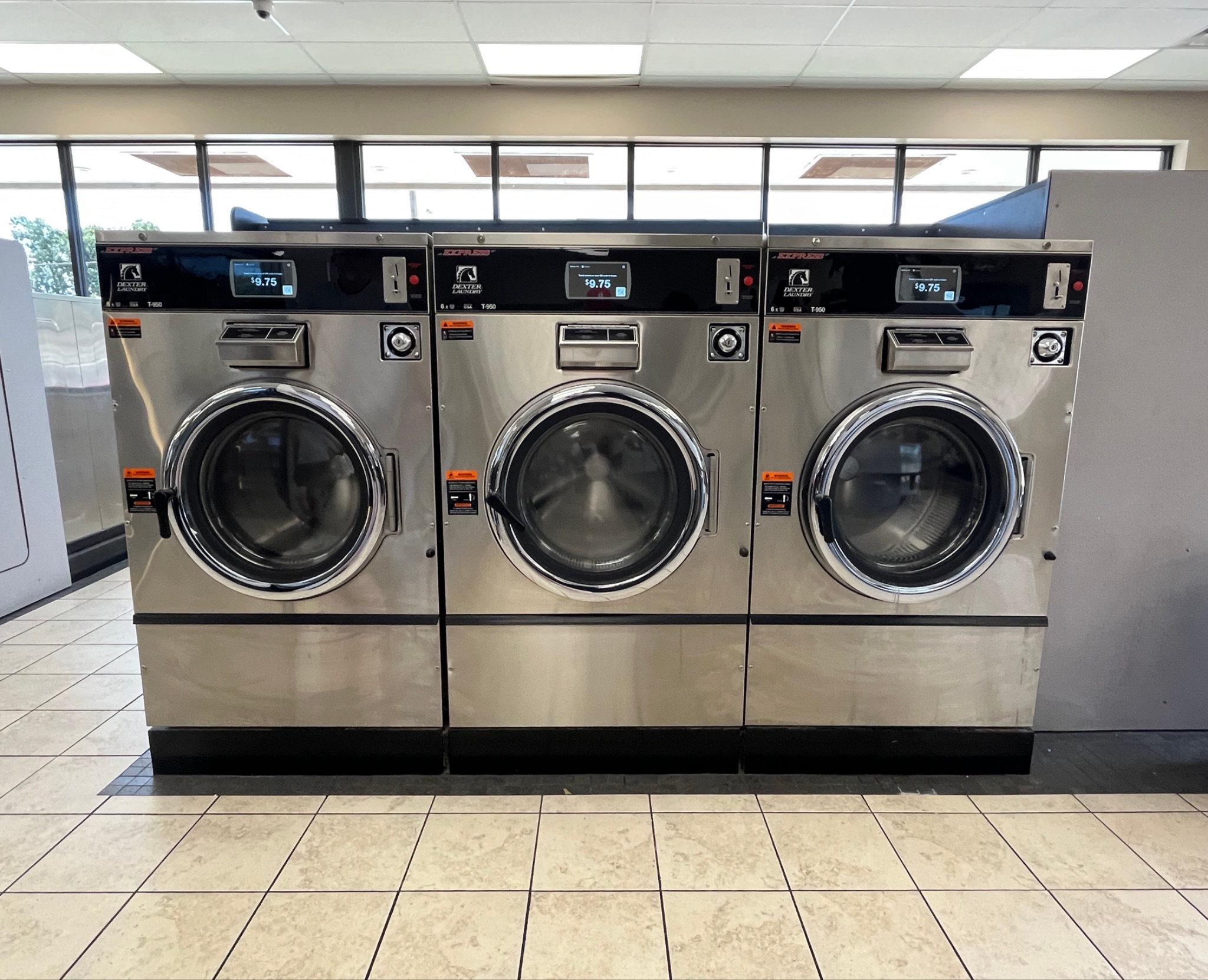 Three large washing machines in laundromat