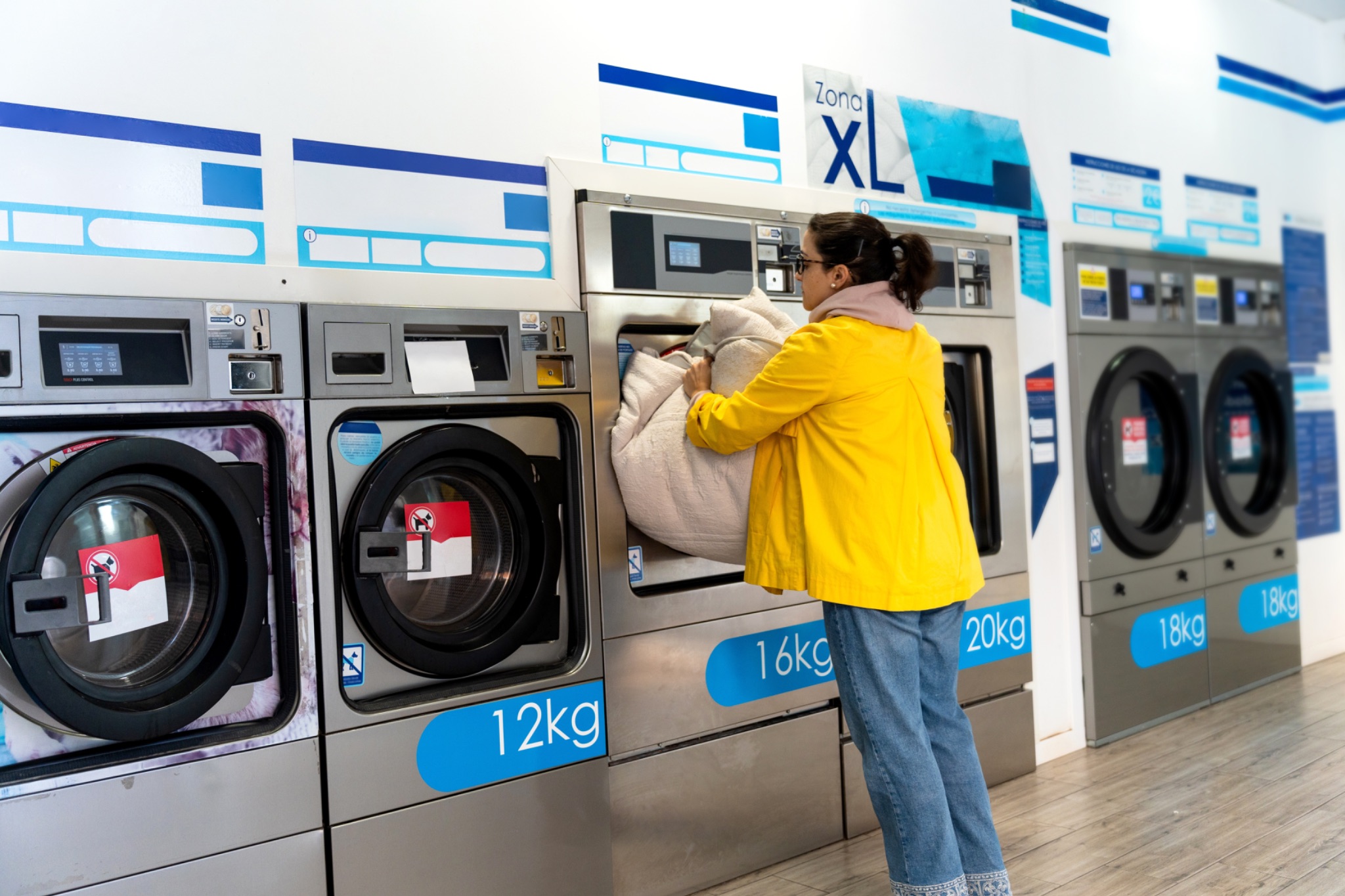 Woman placing laundry in laundromat machine