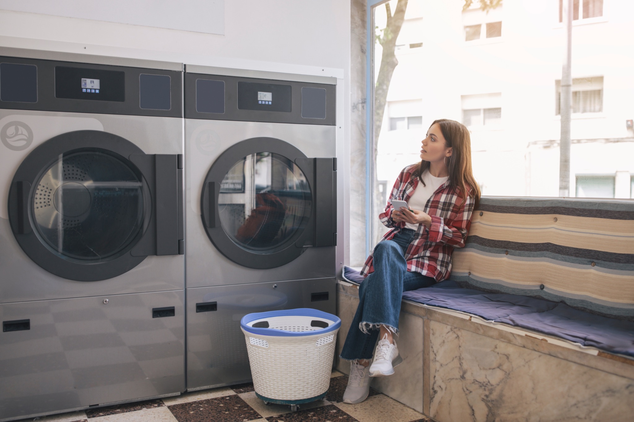 Woman sitting near laundry machines