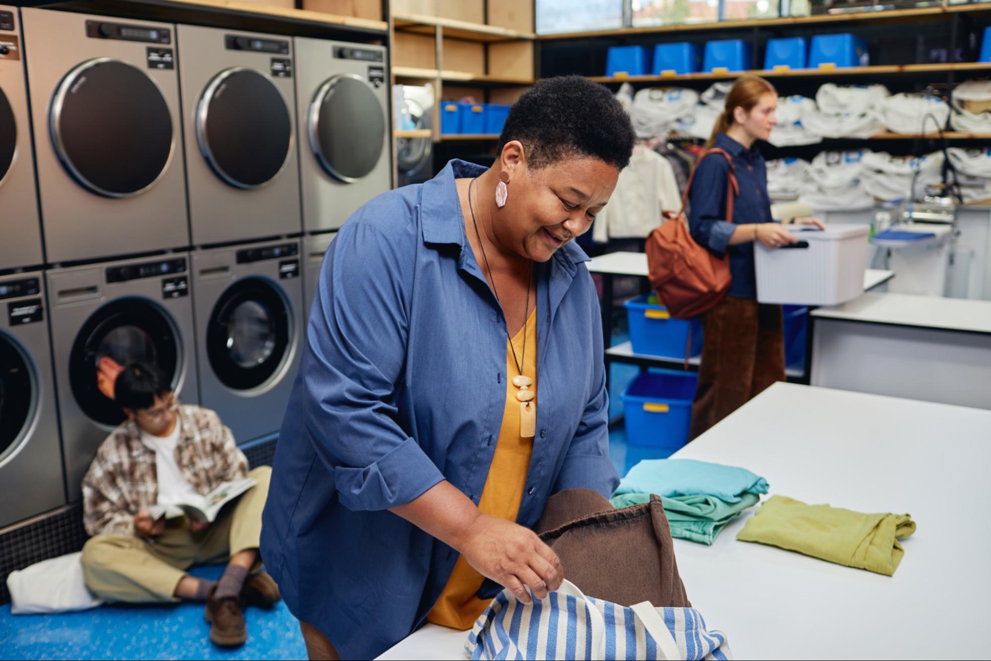 Woman folding clothes at laundromat